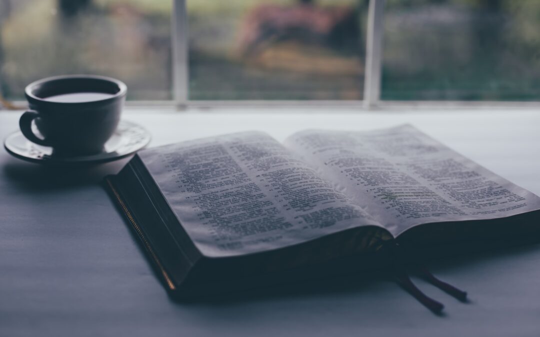 white book page beside black ceramic mug on table